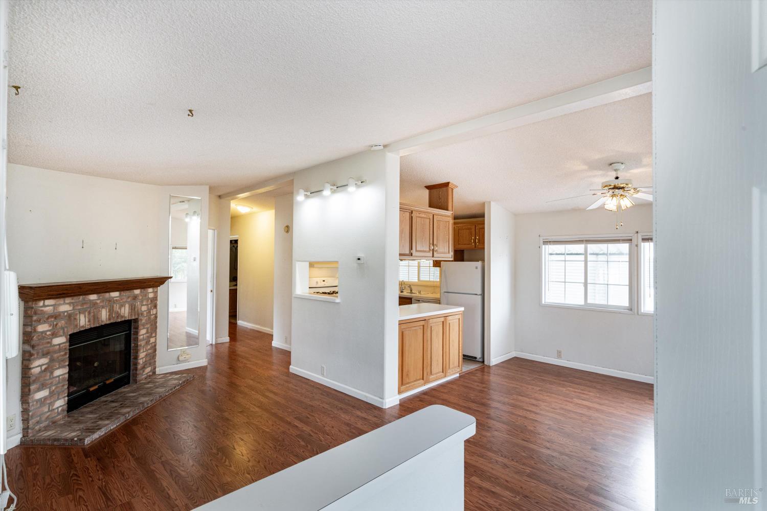 146 Westgate Circle Santa Rosa, CA 95401 - Photo 10 of 41 a view of a kitchen and an empty room with wooden floor a fireplace