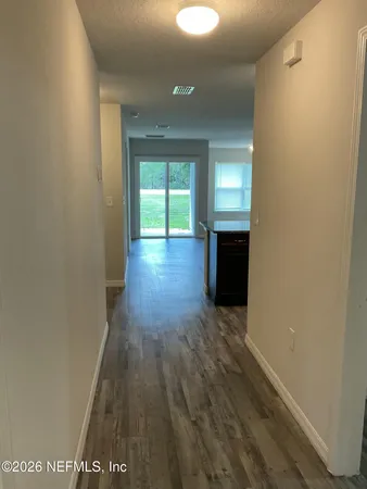 a view of a hallway with wooden floor and stairs
