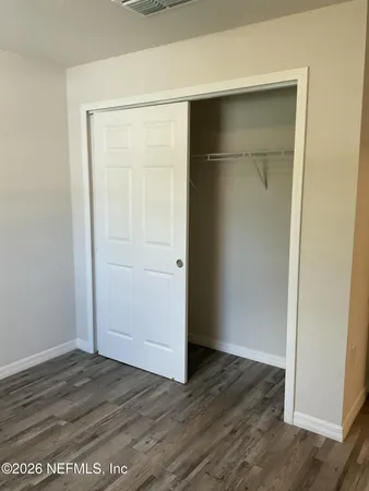 an empty room with wooden floor and closet