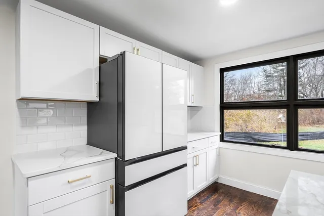 a kitchen with a refrigerator and a large window