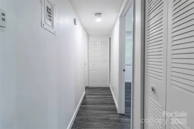 a view of a hallway with wooden floor and staircase
