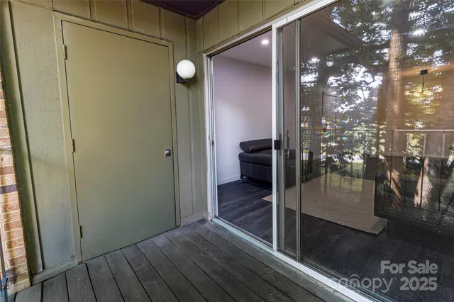 a view of a hallway with wooden floor and a bathroom