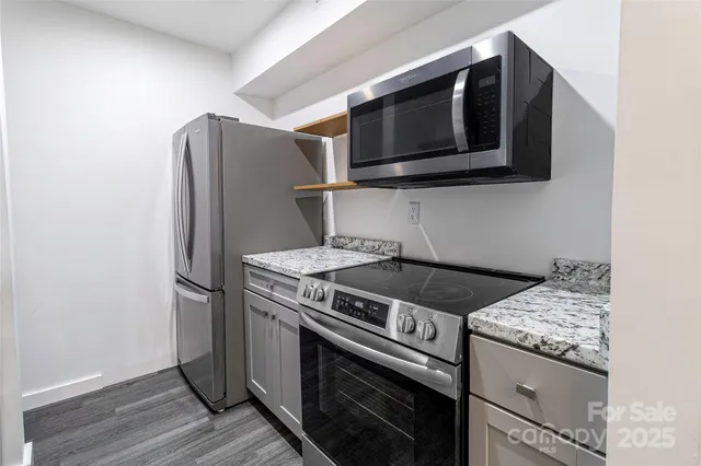 a kitchen with stainless steel appliances granite countertop a stove microwave and refrigerator