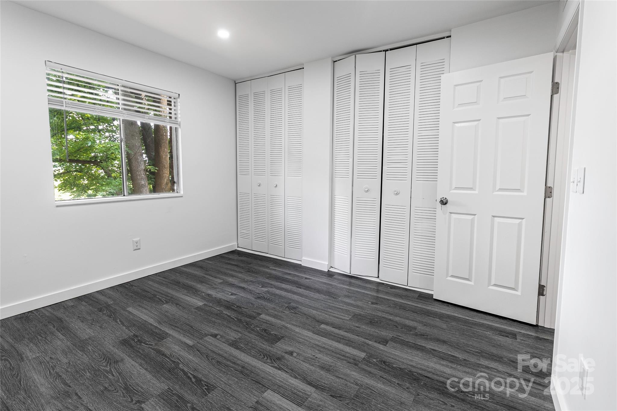 338 Orchard Trace Lane, Unit 8 Charlotte, NC 28213 - Photo 9 of 15 a view of an empty room with wooden floor and a window
