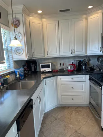 a kitchen with stainless steel appliances granite countertop a refrigerator sink and cabinets