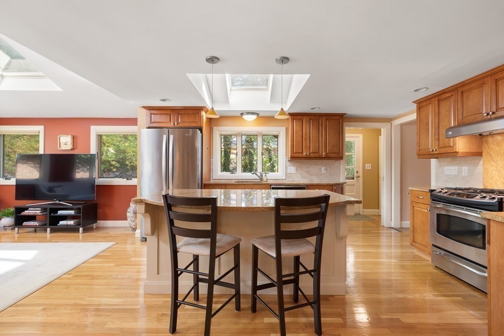 120 Country Club Road Newton, MA 02459 - Photo 5 of 25 a kitchen with stainless steel appliances granite countertop a stove top oven a sink a dining table and chairs with wooden floor