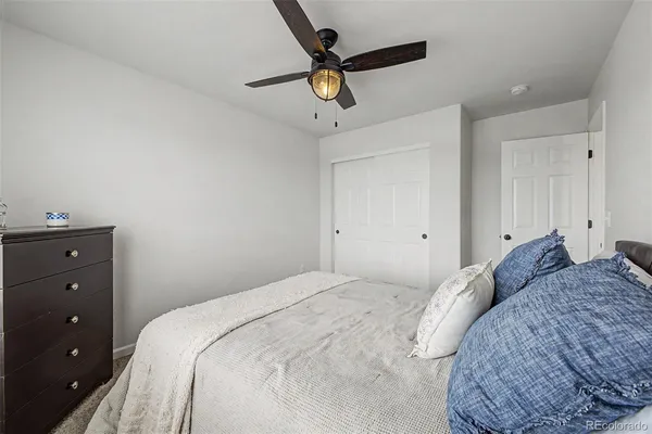 a bedroom with a bed a chandelier and a window