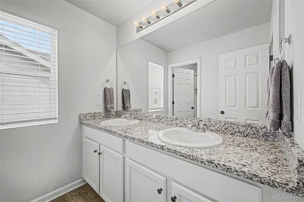 a bathroom with a granite countertop sink and a mirror