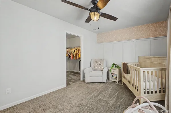 a living room with white walls and ceiling fan