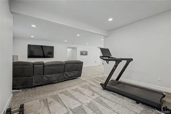 a living room with furniture gym equipment and a flat screen tv
