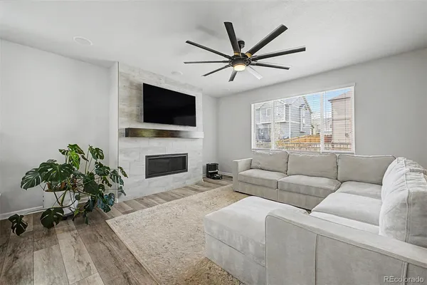 a living room with furniture a fireplace and a flat screen tv