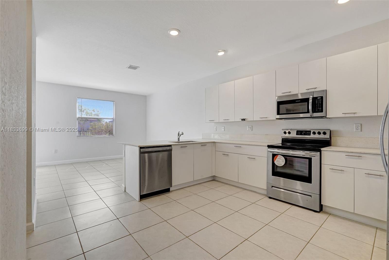 Gladeview Miami, FL 33147 - Photo 7 of 42 a kitchen with granite countertop white cabinets and stainless steel appliances