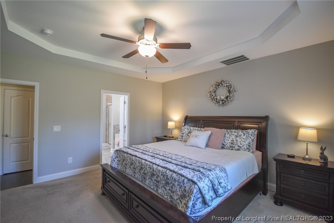 515 Bristling Pine Road Carthage, NC 28327 - Photo 26 of 40 a bedroom with a large bed and a chandelier