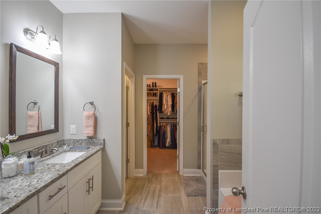515 Bristling Pine Road Carthage, NC 28327 - Photo 27 of 40 a en suite bathroom with a granite countertop sink and a mirror
