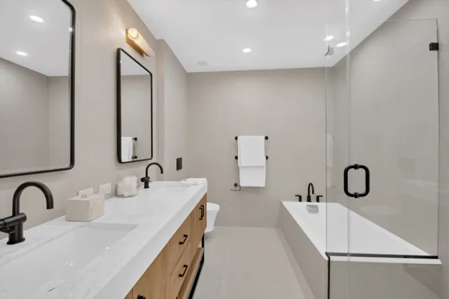 a bathroom with a sink a toilet and shower