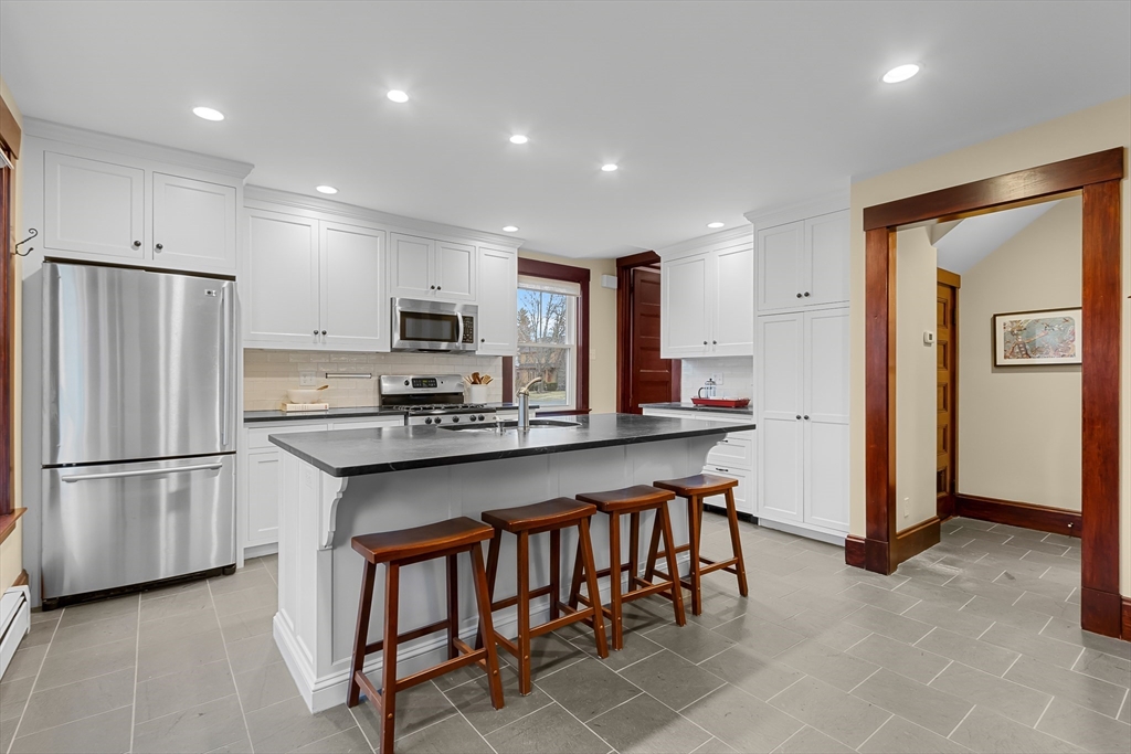25 Bradford Street Needham, MA 02492 - Photo 14 of 38 a kitchen with stainless steel appliances granite countertop a refrigerator and a stove top oven