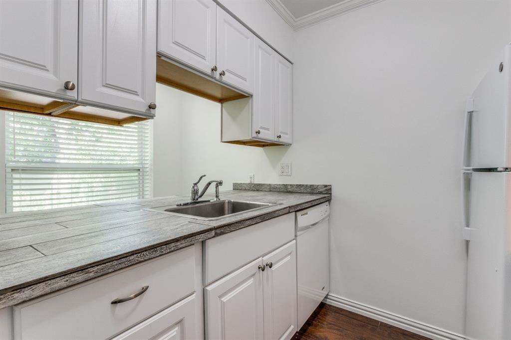 5508 Tremont Street, Unit 8 Dallas, TX 75214 - Photo 9 of 12 Kitchen featuring white cabinetry, white appliances, dark wood-style flooring, ornamental molding, and light countertops