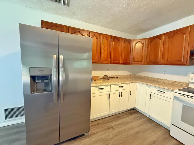 a kitchen with cabinets stainless steel appliances and a counter space