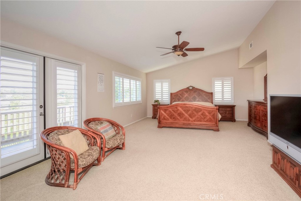 45316 St Tisbury Street Temecula, CA 92592 - Photo 23 of 62 a living room with a bed furniture flat screen tv and windows