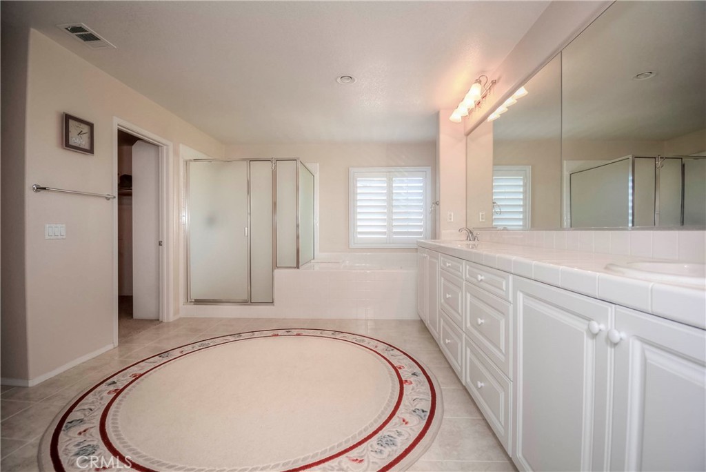45316 St Tisbury Street Temecula, CA 92592 - Photo 28 of 62 a bathroom with a sink a mirror and a shower