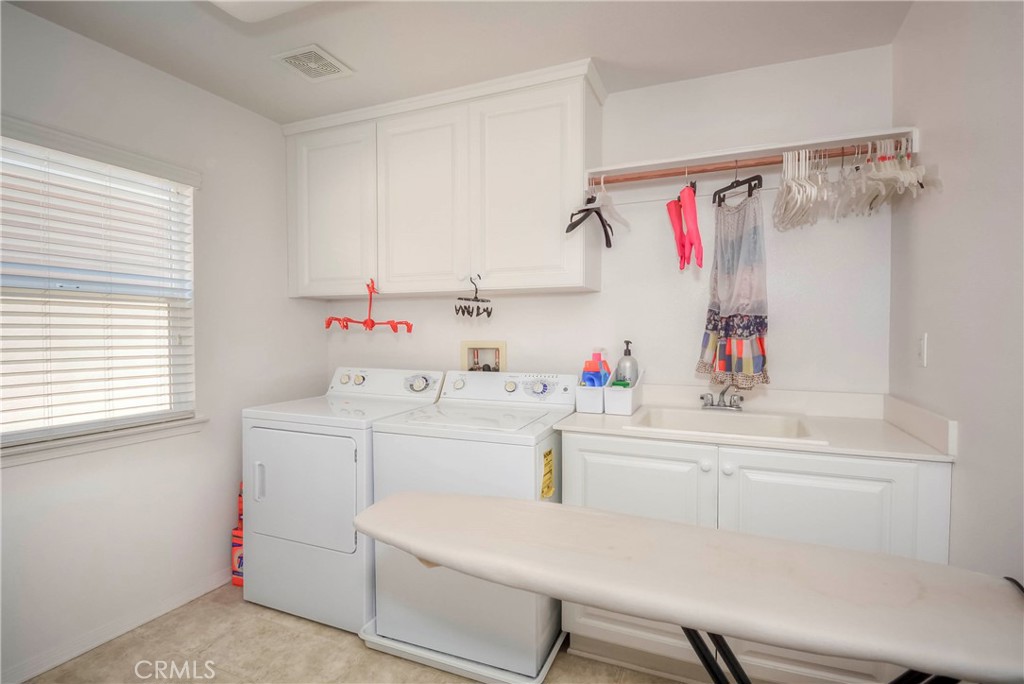 45316 St Tisbury Street Temecula, CA 92592 - Photo 49 of 62 a utility room with cabinets washer and dryer