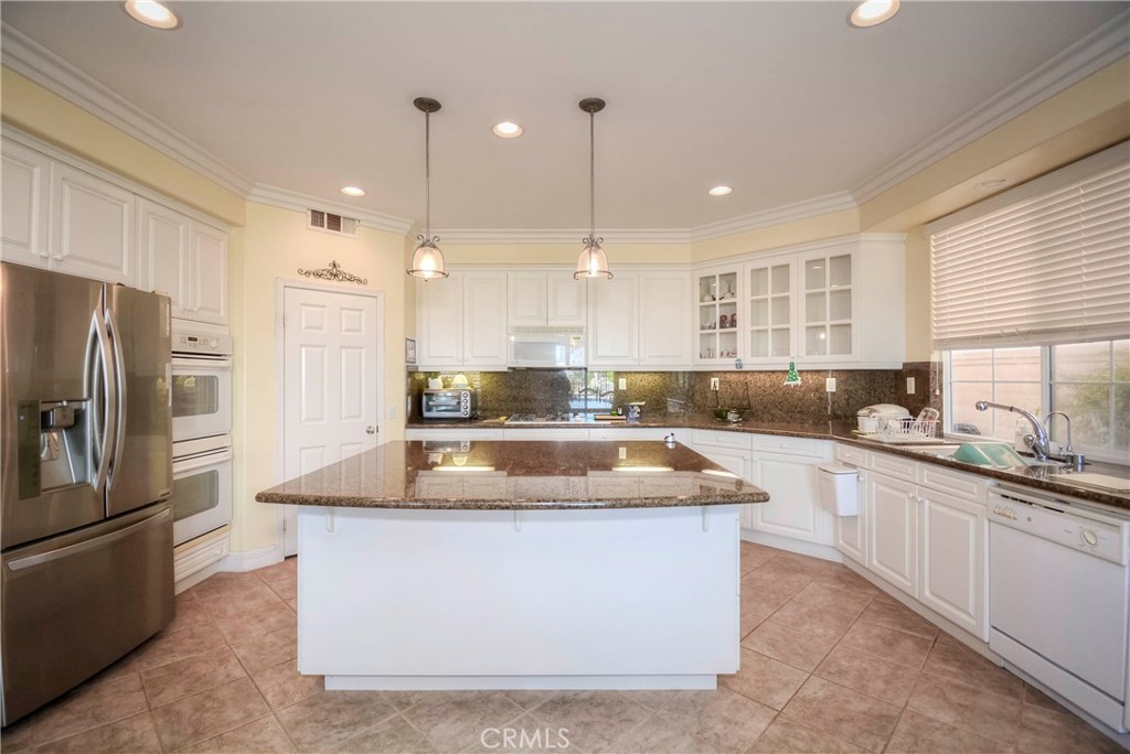 45316 St Tisbury Street Temecula, CA 92592 - Photo 10 of 62 a large kitchen with a center island a counter space stainless steel appliances and windows