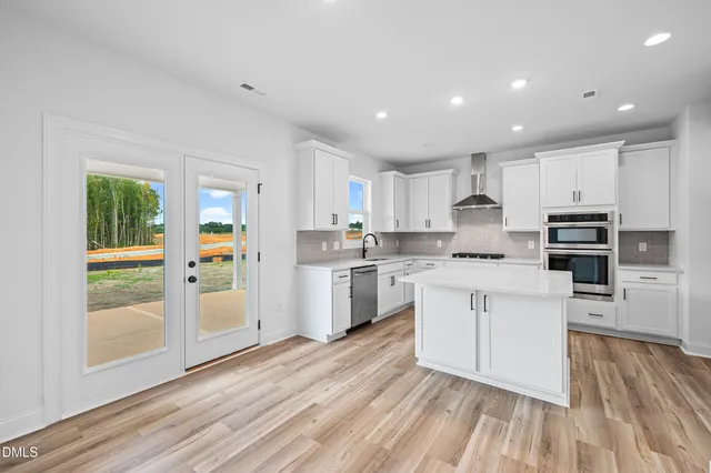 a large kitchen with kitchen island a sink stainless steel appliances and cabinets