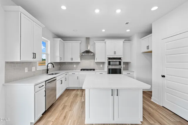 a kitchen with stainless steel appliances a stove sink microwave and cabinets