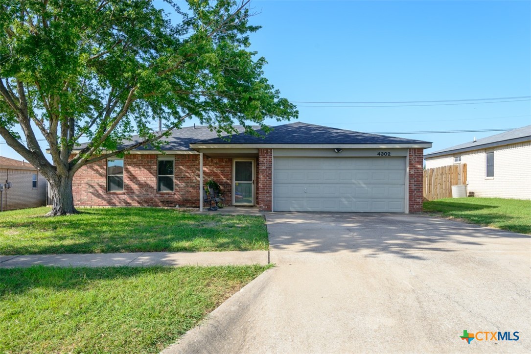 4302 Sand Dollar Drive Killeen, TX 76549 - Photo 1 of 1 a front view of a house with a garden and trees