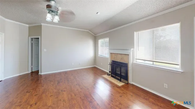 a view of an empty room with wooden floor