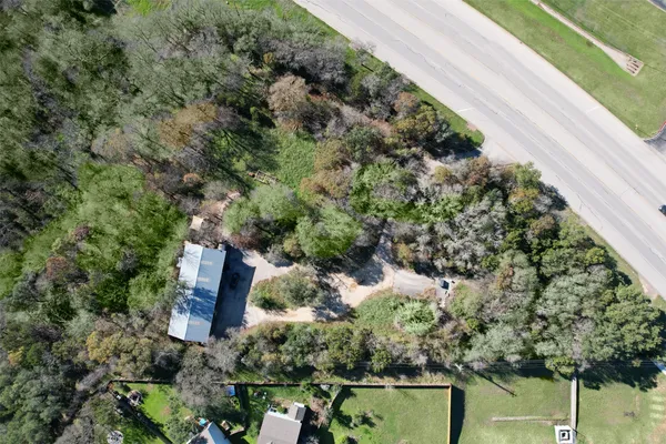 an aerial view of residential house with outdoor space and trees all around