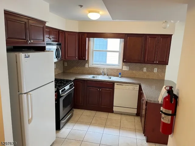 a kitchen with a refrigerator sink and wooden cabinets