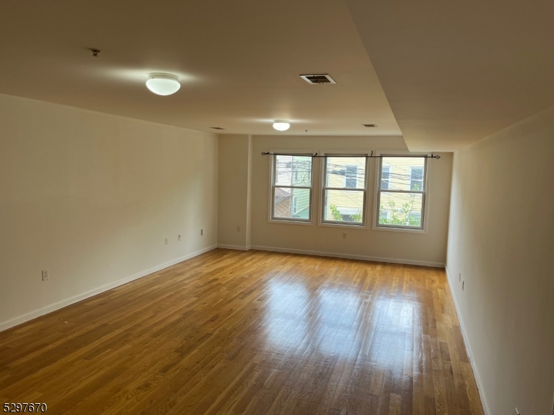 157 Lafayette Street, Unit 2 Newark, NJ 07105 - Photo 6 of 12 wooden floor in an empty room with a window