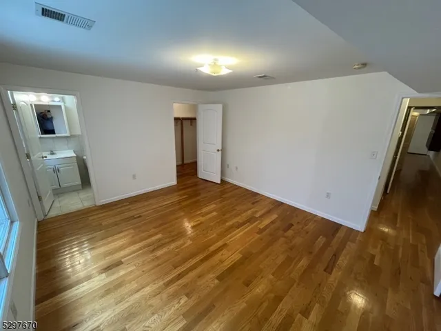 a view of a room with wooden floor and entryway