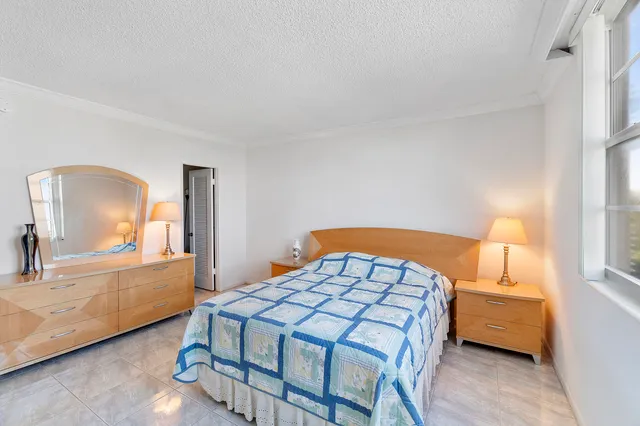 a bedroom with a bed a mirror and a dresser