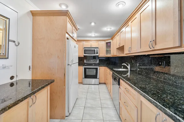 a kitchen with stainless steel appliances granite countertop a sink and a stove