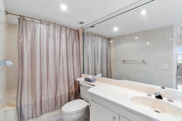a bathroom with a sink a toilet and shower curtain