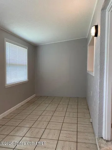 an empty room with white walls and tiles