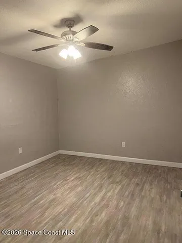 an empty room with a fan and a window