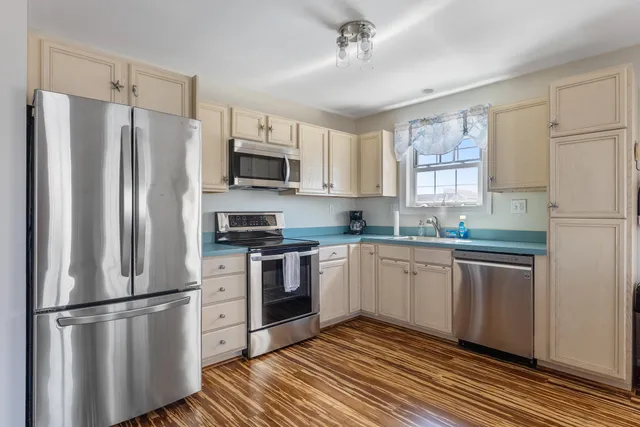 a kitchen with stainless steel appliances a refrigerator sink and microwave