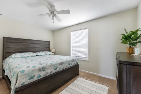 a bed sitting in a bedroom next to a window and a chandelier