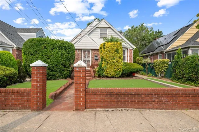 a front view of a house with a garden and plants
