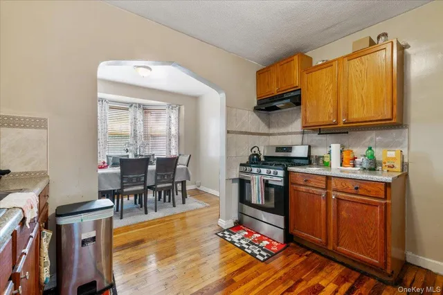 a kitchen with stainless steel appliances granite countertop a stove top oven a sink dishwasher and cabinets with wooden floor