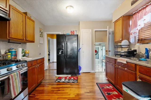 a kitchen with stainless steel appliances granite countertop a refrigerator a stove and a sink