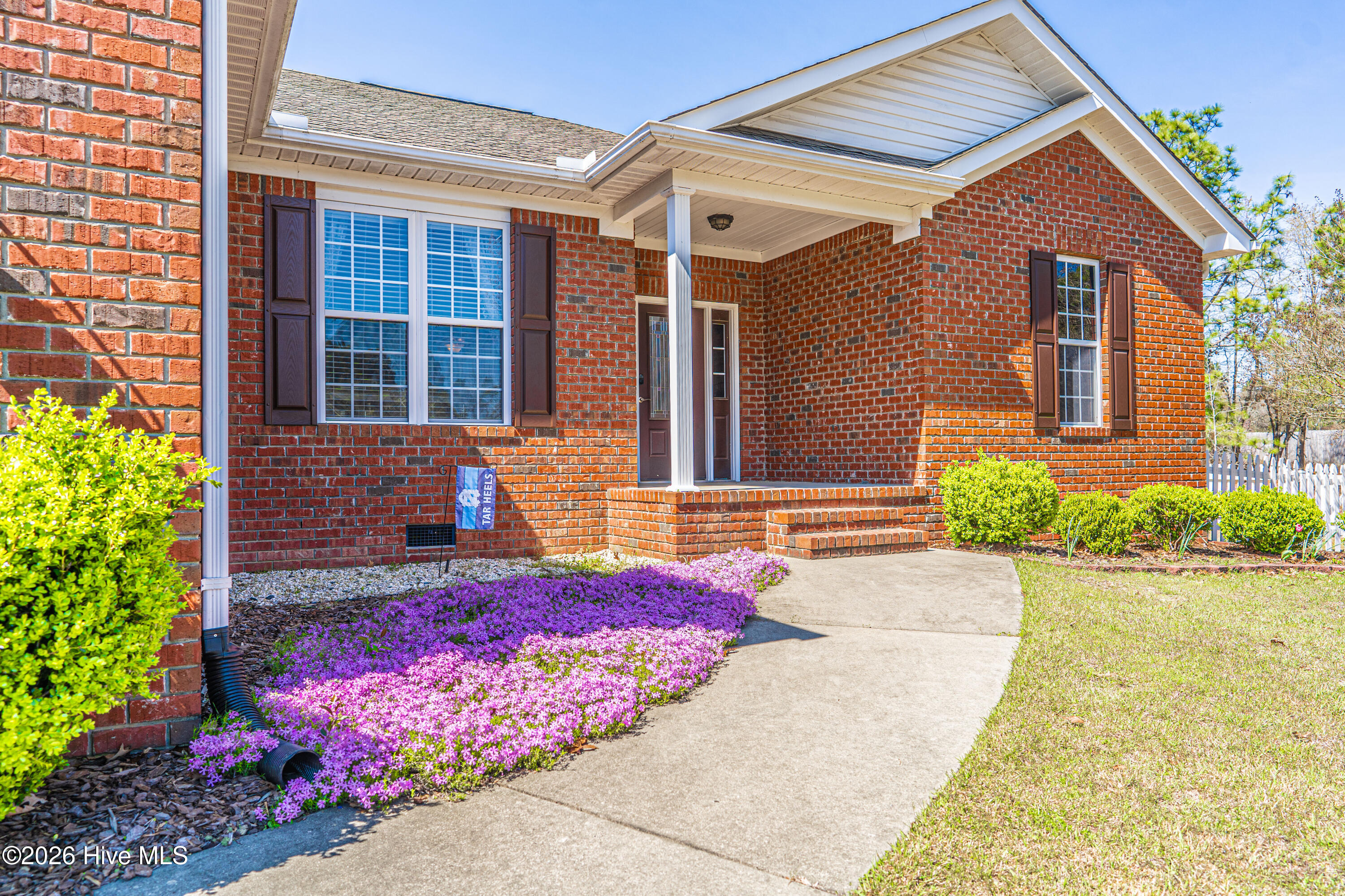 1320 Burning Tree Road Pinehurst, NC 28374 - Photo 3 of 60 Concrete walkway with aesthetic landscape entrance