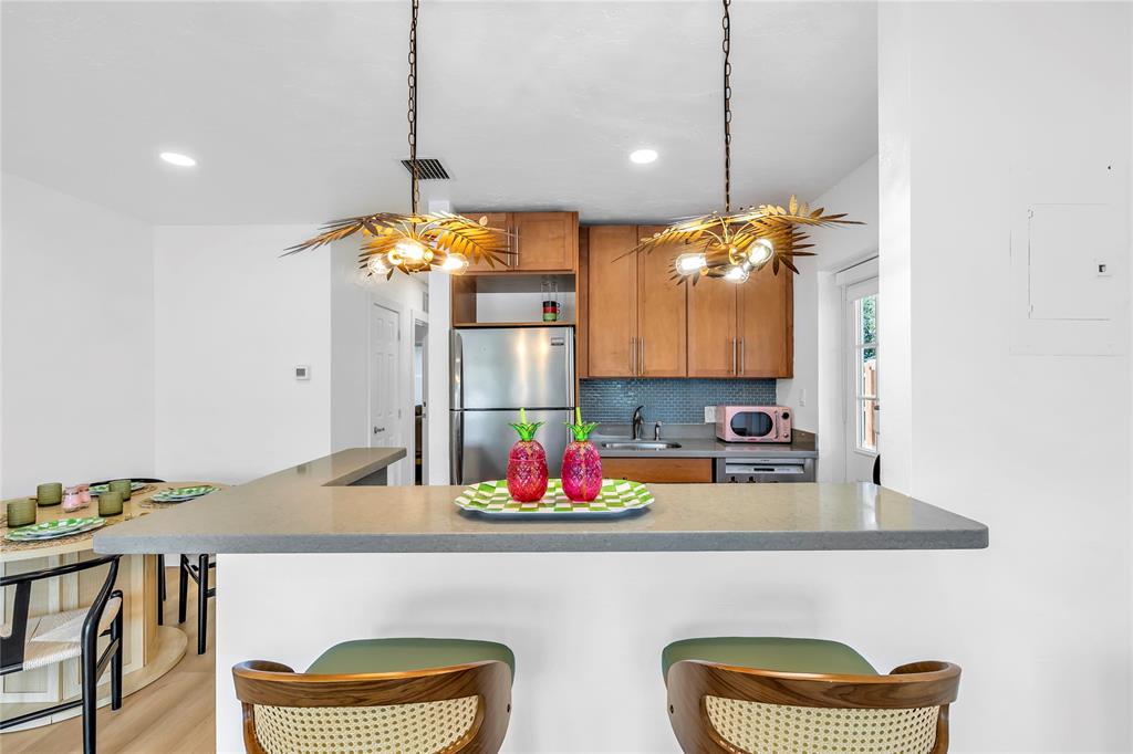 2412 Northeast 4th Street, Unit W Pompano Beach, FL 33062 - Photo 15 of 25 a kitchen with a table and a chandelier