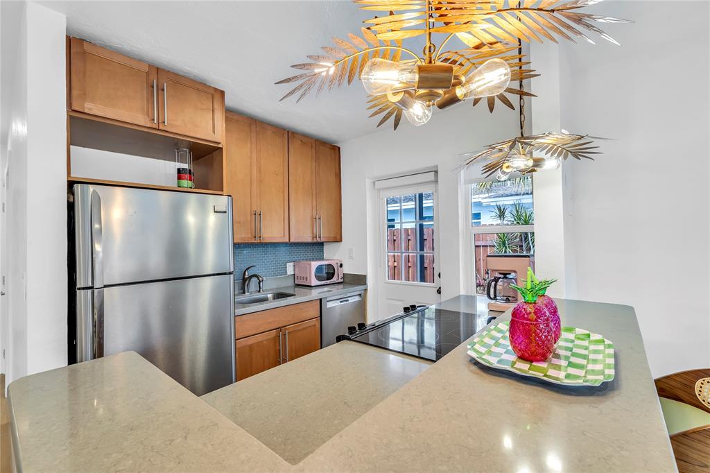 2412 Northeast 4th Street, Unit W Pompano Beach, FL 33062 - Photo 16 of 25 a kitchen with stainless steel appliances granite countertop a refrigerator sink and cabinets