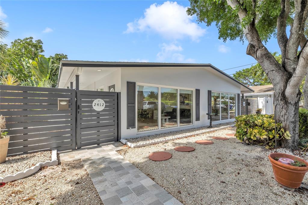 2412 Northeast 4th Street, Unit W Pompano Beach, FL 33062 - Photo 7 of 25 a front view of a house with a yard
