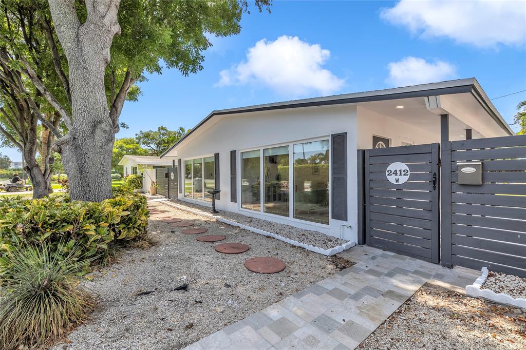 2412 Northeast 4th Street, Unit W Pompano Beach, FL 33062 - Photo 8 of 25 a front view of a house with garden