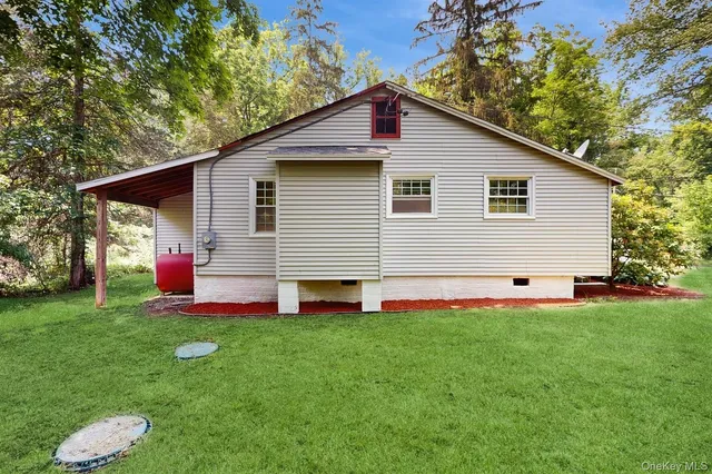 a front view of house with yard and trees in the background
